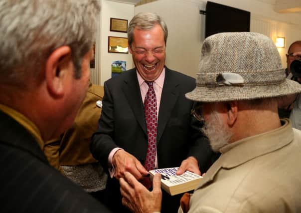 Ukip party leader Nigel Farage signs an autograph during a visit to Basildon, Essex