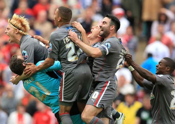Rotherham United goalkeeper Adam Collin is mobbed by his team-mates after saving the deciding penalty in the shoot-out during the Sky Bet League One Play Off Final at Wembley