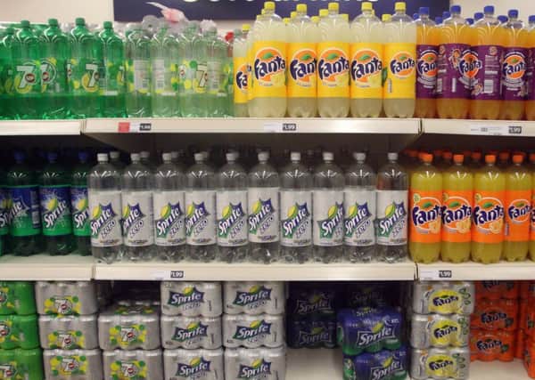 Health warnings should be added to sugary drinks in an attempt to make them as socially unacceptable as cigarettes, a leading figure in public health has said