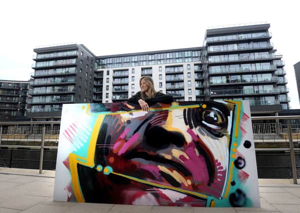 Lucy Whalley (co-ordinator for Allied London) with a section of one of the pieces in front of the horadings where the work will eventually be hung.