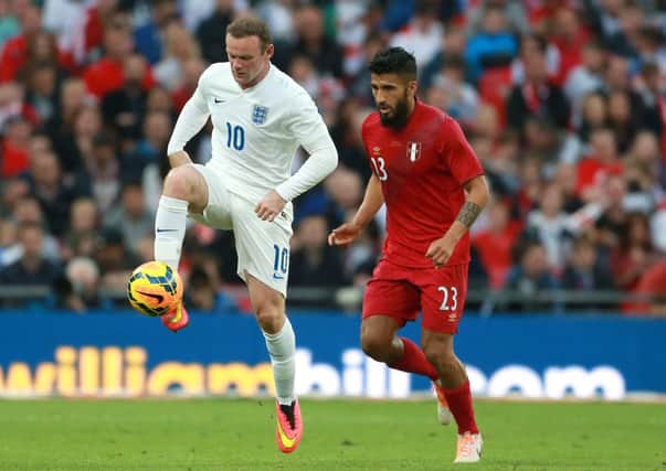 MAIN MAN: England's Wayne Rooney, left, in action against Peru on Friday night.