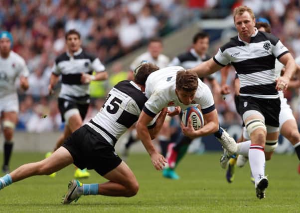 England's Ollie Deveto is tackled by Barbarians Huan Martin Hernandez.