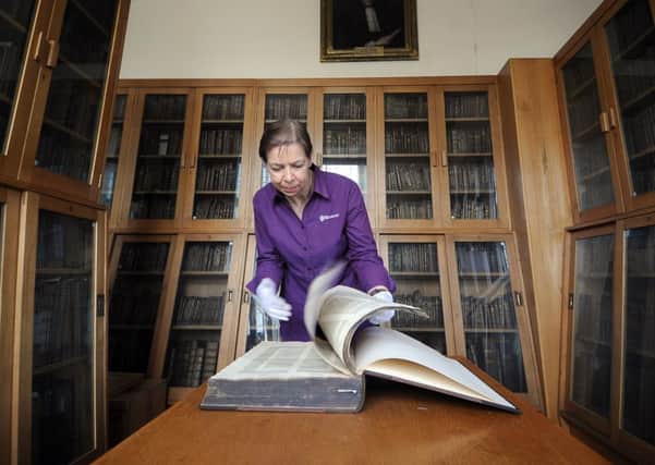 Library custodian Gill Taylor has a look through the 1480 Holy Bible.
 Picture by Gerard Binks