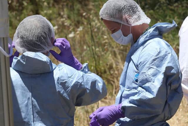 Forensic police officers preparing to examine a hole in an area of wasteland to search for Madeleine McCann in the town of Praia da Luz in Portugal