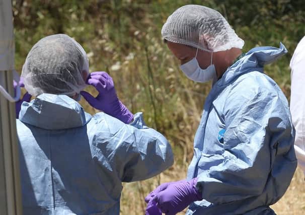 Forensic police officers preparing to examine a hole in an area of wasteland to search for Madeleine McCann in the town of Praia da Luz in Portugal