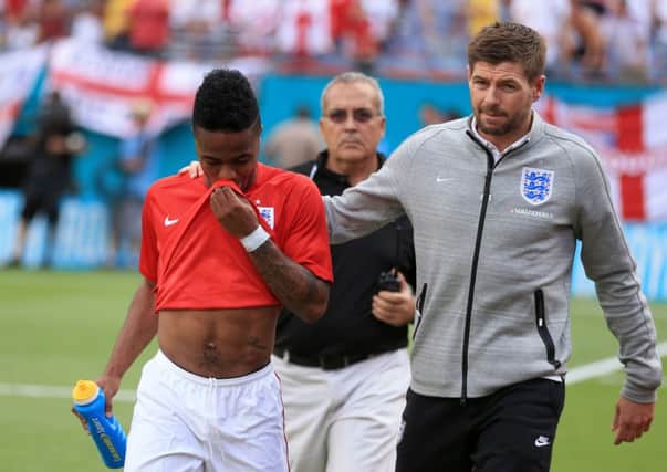 England's Steven Gerrard, right, consoles team-mate Raheem Sterling (left) after he is sent off against Ecuador.