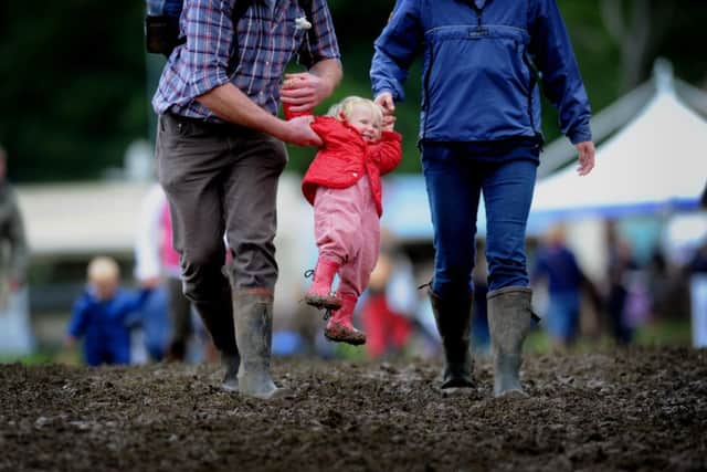 Charlotte Ingham is lifted out of the mud by her parents Louise and James. Pictures by Simon Hulme