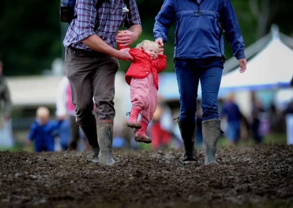 Charlotte Ingham is lifted out of the mud by her parents Louise and James. Pictures by Simon Hulme