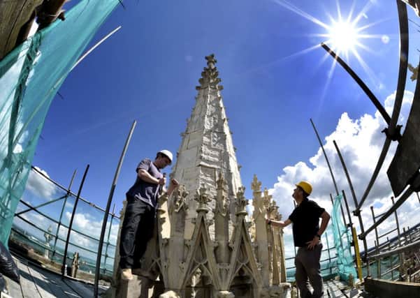Stonemason Lindsay Howgarth (left), 34, works on the final stages of the East Tower at York Minster. Picture: Owen Humphreys/PA