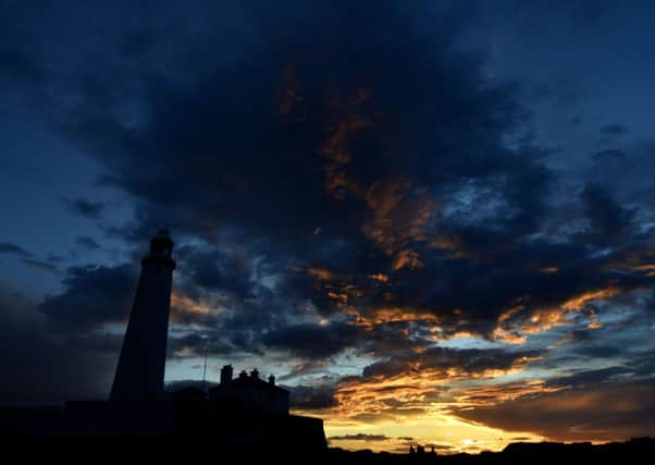 The sun sets behind St Mary's Lighthouse near Whitley Bay, as the warm weather continues