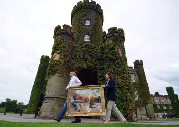 Artist Emerson Mayers and Swinton Park owner Felicity Cunliffe-Lister carry a painting by Harrogate artist Chloe Holt into Swinton Park. Pictures by Gerard Binks