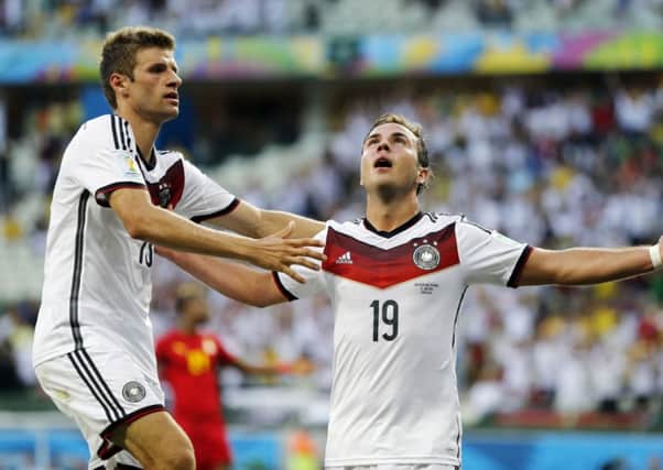 Germany's Mario Goetze celebrates with Thomas Mueller, left, after scoring the opening goal during the group G World Cup soccer match between Germany and Ghana.