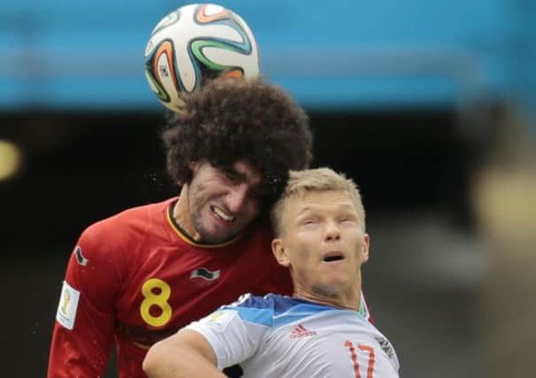 Belgium's Marouane Fellaini, left, battles for an aerial ball with Russia's Oleg Shatov during the group H World Cup soccer match between Belgium and Russia at the Maracana stadium. (AP Photo/Ivan Sekretarev)
