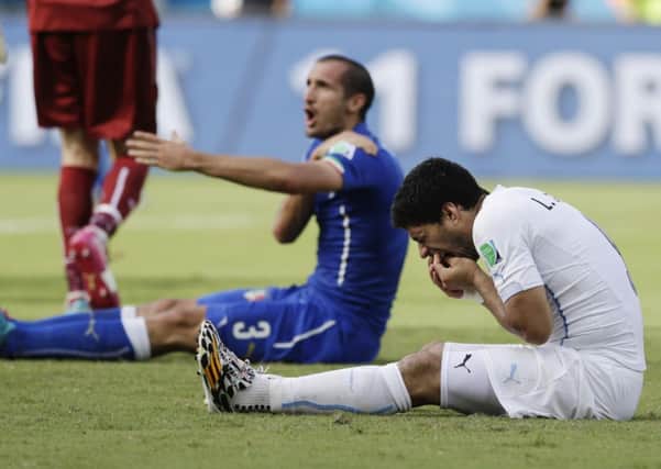 Italy's Giorgio Chiellini complains after Uruguay's Luis Suarez ran into his shoulder with his teeth during the group D World Cup soccer match between Italy and Uruguay. (AP Photo/Ricardo Mazalan)