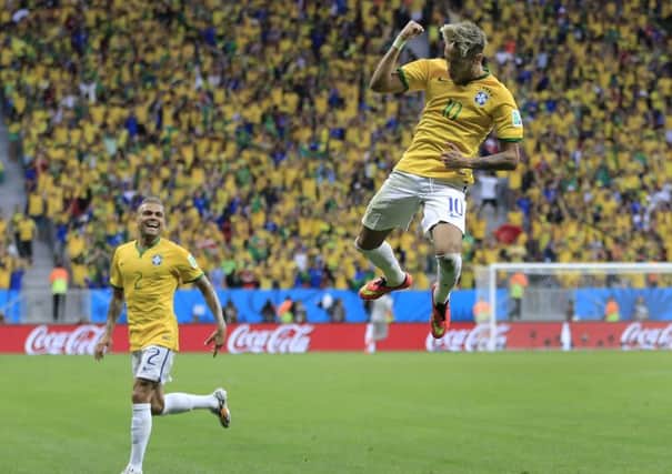 Brazil's Neymar leaps in the air to celebrate after scoring his side's second goal against Cameroon.