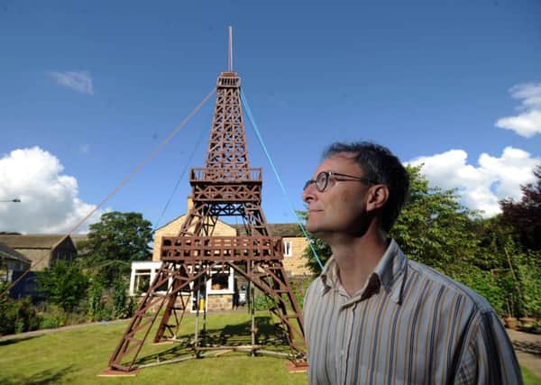 Charles Prest by the model of the Eiffel Tower at Burley in Wharfedale
