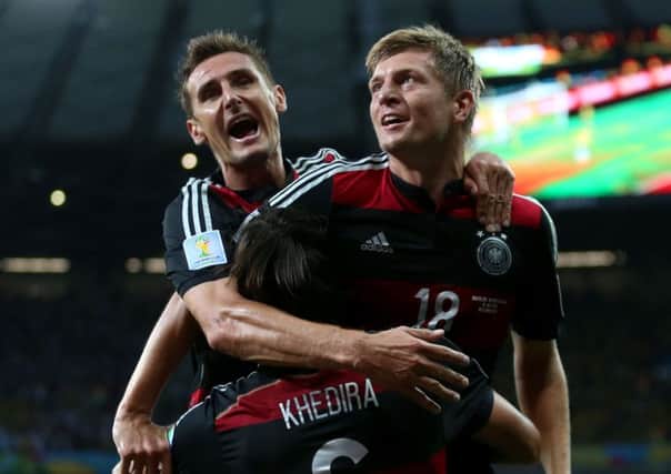 Germany's Toni Kroos celebrates scoring his side's fourth goal of the game with team-mate Germany's Sami Khedira (6) and Miroslav Klose (left)