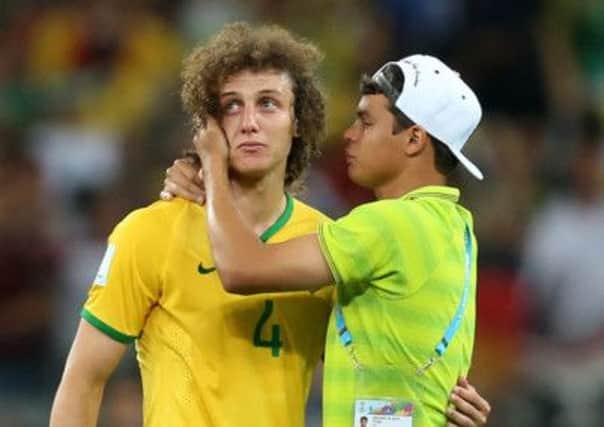 Brazil's David Luis (left) has to be consoled by teammate Thiago Silva (right).