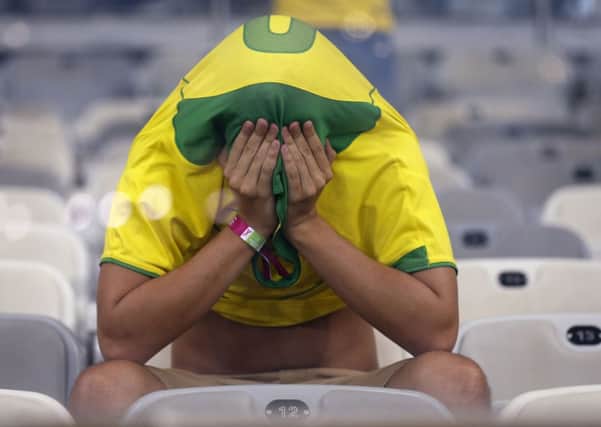 A Brazil fan covers his face after his country's World Cup humiliation.