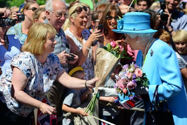 The Queen receives flowers from Jan Norris from Sheffield on her visit to Chatsworth. PIC: Scott Merrylees