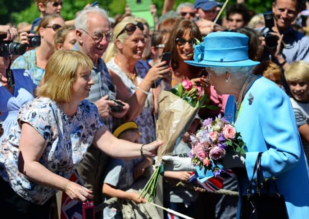 The Queen receives flowers from Jan Norris from Sheffield on her visit to Chatsworth. PIC: Scott Merrylees