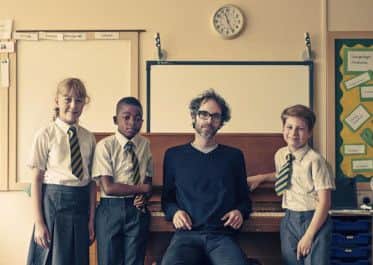 Children at the piano with James Rhodes. From left: Darcey, Tyronne and CadenThey from St Teresa's Primary School