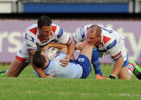 Wakefield's Lee Gilmour and Richard Moore gets to grips with Widnes' Stefan March.