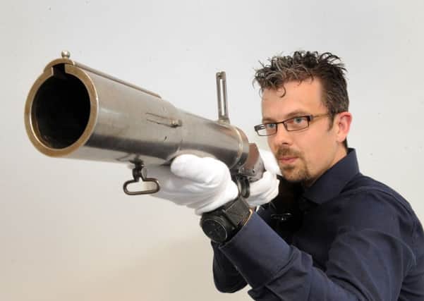 Jonathan Ferguson, curator of firearms, with a Blanch-Chevallier Grenade Launcher.