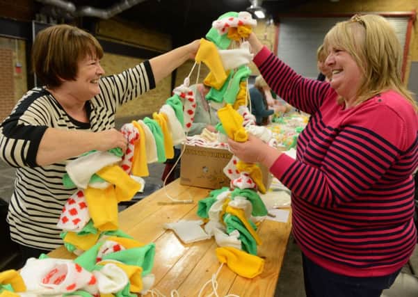 Ellie Wilkinson and Val Sinclair stringing together knitted jerseys before they were hung around Harrogate for the Grand Depart weekend. Picture Bruce Rollinson