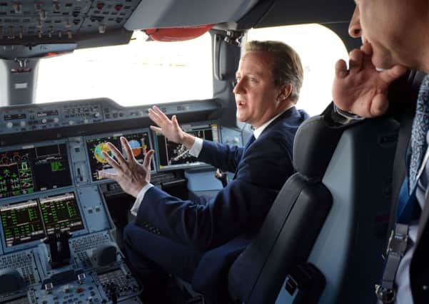 Prime Minister David Cameron sits in the co-pilots seat in the cockpit as he is shown around an Airbus A350 during a visit to the 2014 Farnborough Airshow in Hampshire.