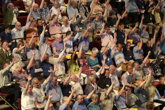 Members of the Church of England's Synod vote on one of the motions during the session during which approved the consecration of women bishops