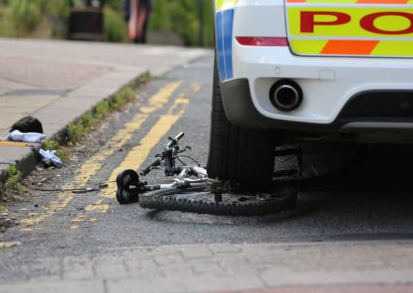 The bike under the wheel of the police car and the recovered firearm. Pictures: Ross Parry Agency