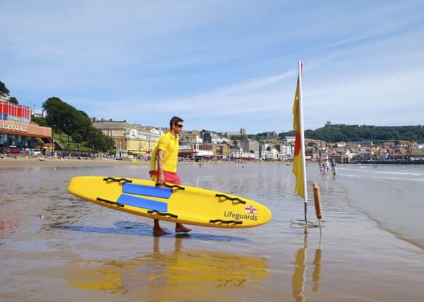 Lifeguard Gareth Oxley keeps an eye on paddlers and bathers on the South Bay beach in Scarborough. Picture: Tony Bartholomew