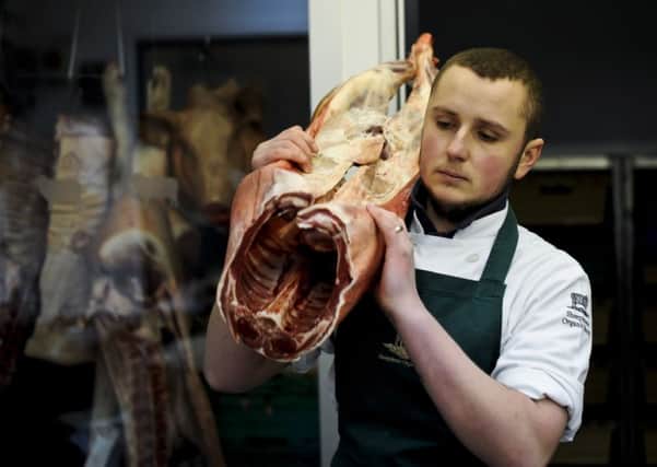 Butcher Paul Gyorgy carries a lamb carcass at the Sheepdrove Organic Farm shop in Bristol. Photo: Ben Birchall/PA Wire