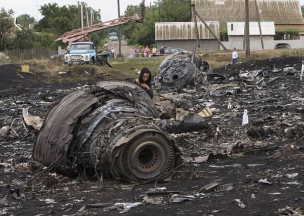 A woman walks at the site of a crashed Malaysia Airlines passenger plane near the village of Rozsypne, eastern Ukraine
