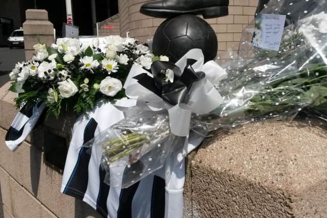 Flowers and football shirts around the Sir Bobby Robson statue outside Newcastle football ground after two fans died on board flight MH17