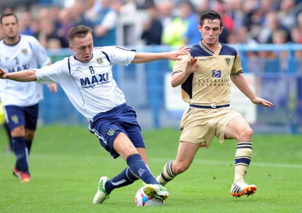 Lewis Cook battles with Guiseley's Jack Stockdill