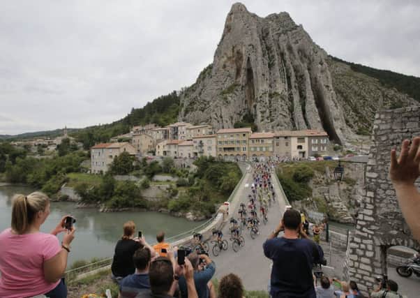 The pack passes a bridge spanning Durance river in Sisteron during the fifteenth stage of the Tour de France. (AP Photo/Christophe Ena)