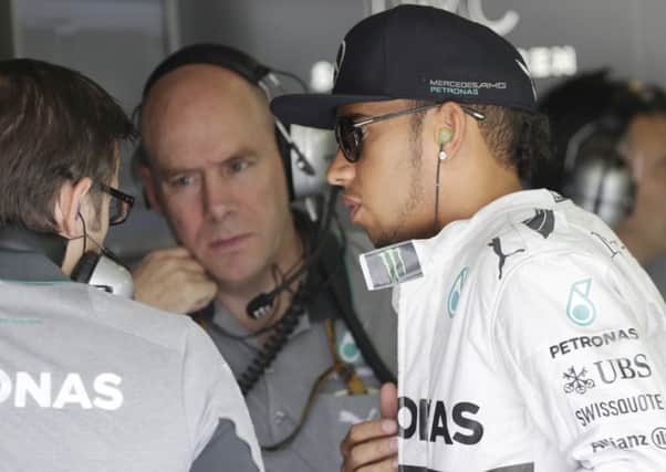 Mercedes driver Lewis Hamilton of Britain talks to his technicians during the free practice.