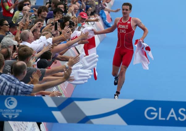 England's Alistair Brownlee high fives the crowd as he approachs the line before winning the Mixed Team Relay at Strathclyde Country Park during the 2014 Commonwealth Games near Glasgow.