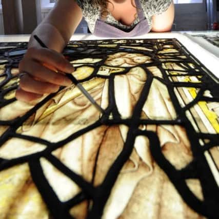York Glaziers' Trust head glazier Nick Teed installs panels in the Great East Window of York Minster