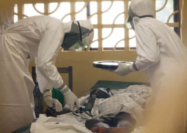 Dr. Kent Brantly, left, treats an Ebola patient at the Samaritan's Purse Ebola Case Management Center in Monrovia, Liberia.