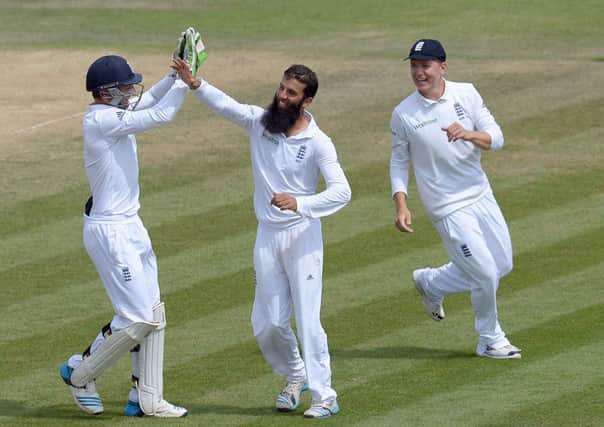 England's Moeen Ali celebrates a wicket with team-mates Gary Ballance, right, and Jos Buttler.