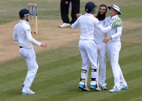 England's Moeen Ali, second right, is congratulated by his team-mates after taking the final wicket on day five.