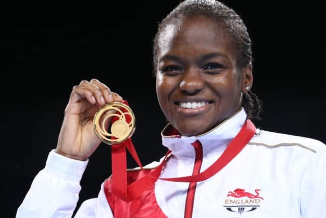 Leeds's Nicola Adams holds up her gold medal for winning the women's flyweight boxing competition.