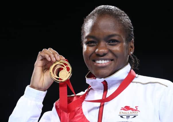 Leeds's Nicola Adams holds up her gold medal for winning the women's flyweight boxing competition.