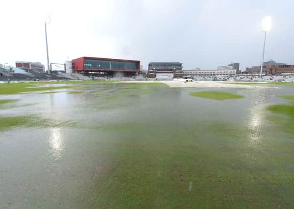 rain stops play: Groundstaff at Old Trafford battled to save the second days play but eventually had to admit defeat.