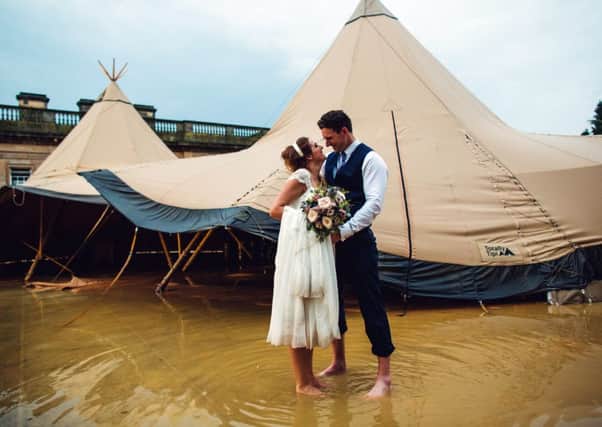 WED, WED, WED: Katy Lomas and her bridegroom Richard Owen brave the deluge that  left them and their guests splashing about in a foot of water. PIC: www.s6photography.co.uk
