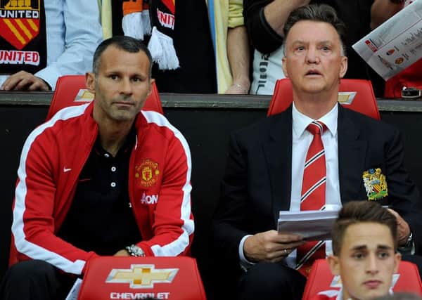 Manchester United manager Louis van Gaal takes his seat next to his assistant Ryan Giggs