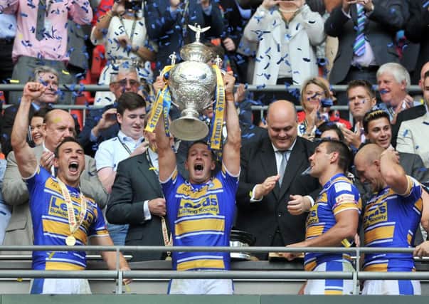 Danny McGuire lifts the Challenge Cup trophy